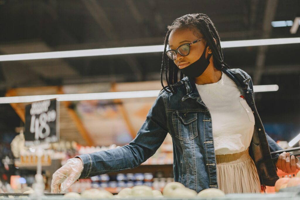 Black girl in a mask buy a food